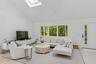 Living room with light wood-type flooring, high vaulted ceiling, and a skylight