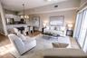 Open concept living and dining room with natural light and balcony overlooking mangroves.