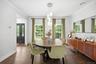 Dining area featuring wood-finish flooring, a contemporary chandelier, crown molding, and multiple windows providing lots of natural light
