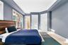 Bedroom featuring ornamental molding, ensuite bath, a closet, and wood finished floors
