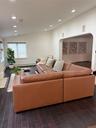 Living area featuring arched walkways, visible vents, dark wood-type flooring, and vaulted ceiling