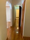 Corridor with hardwood / wood-style flooring and arched walkways