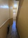Hallway featuring stairway, radiator, and a wainscoted wall