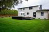 Back of house featuring an outdoor living space, a patio area, brick siding, and a chimney