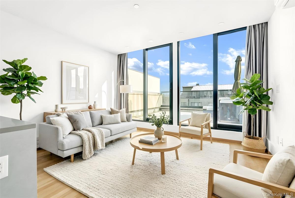 Living area with light wood-style floors and floor to ceiling windows