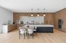 Kitchen with light stone countertops, pendant lighting, a breakfast bar, modern cabinets, and light wood-style flooring