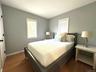Bedroom featuring dark wood-style flooring and baseboards