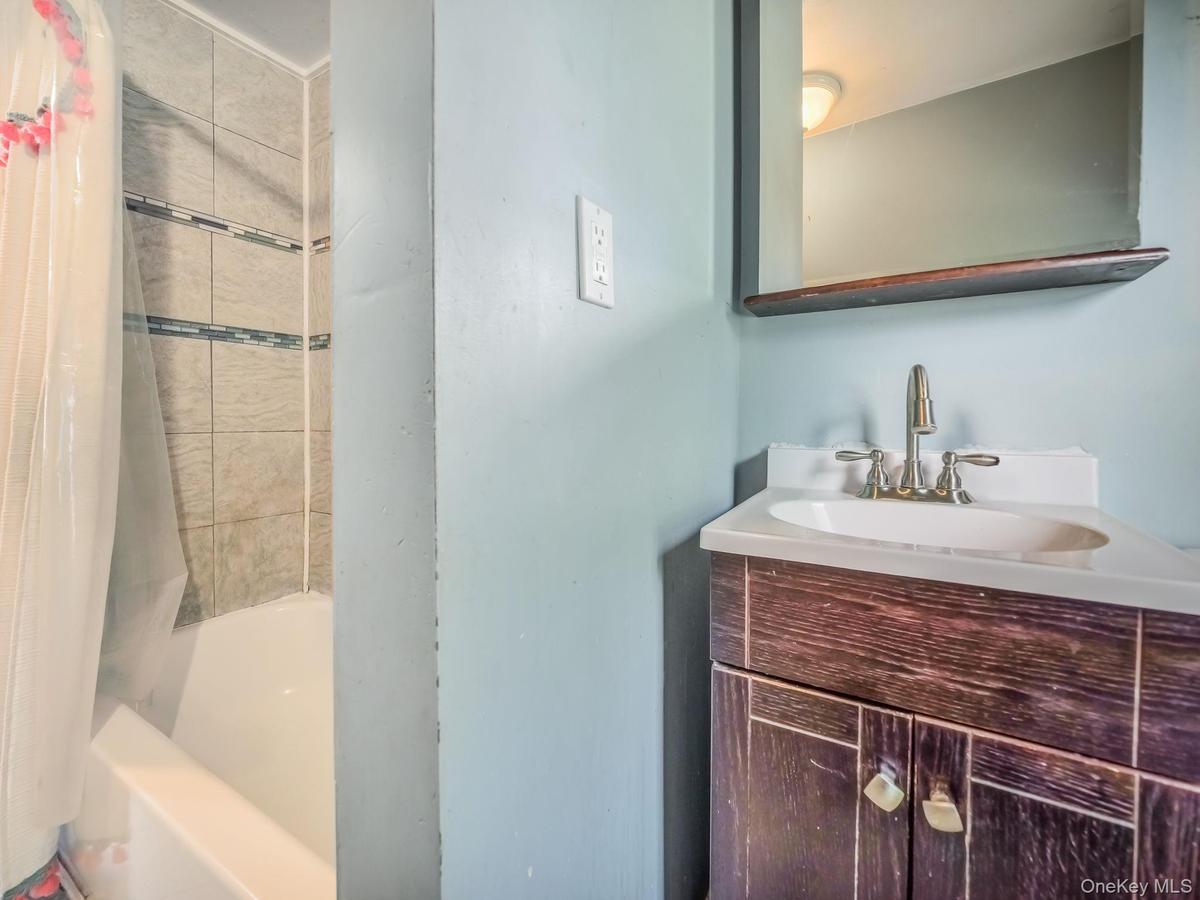 Full bathroom with shower / tub combo with curtain and vanity