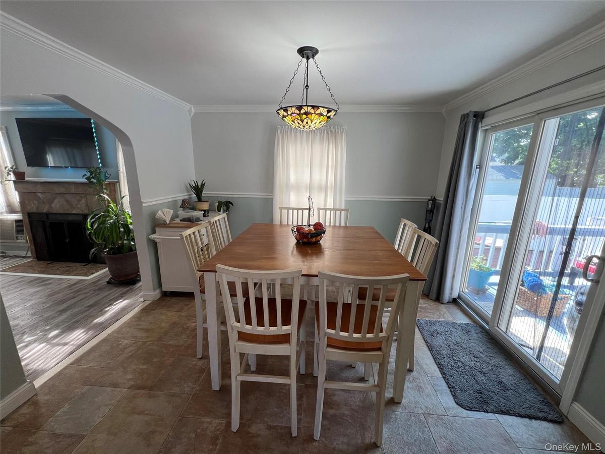 Tile flooring, recessed archway, crown molding, chandelier, sliding glass door
