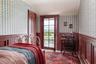 Bedroom with wallpapered walls, access to exterior, a wainscoted wall, lofted ceiling, and a decorative wall
