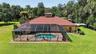 Aerial Rear View Showcasing the Home, Swimming Pool, Screen-Enclosed Lanai, and Backyard