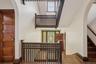 Staircase with arched walkways, plenty of natural light, wood finished floors, and a high ceiling