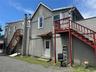 The residential unit offers three generously sized rooms, a full bathroom, powder room, kitchen, and a sun-filled sunroom, providing flexible living s