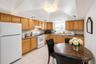 Kitchen featuring abundant wood cabinetry, white appliances, recessed lighting, and a window above the sink