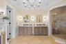 Full bathroom featuring crown molding, a shower stall, vanity, a chandelier, and light tile patterned floors