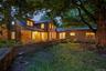 As evening falls, warm light spills from every wing, creating an inviting sense of comfort and timeless country elegance