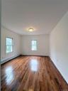 Spare room featuring a baseboard heating unit, plenty of natural light, and dark wood finished floors