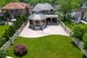 Back of property with french doors, a high end roof, a patio area, stone siding, and a fenced backyard