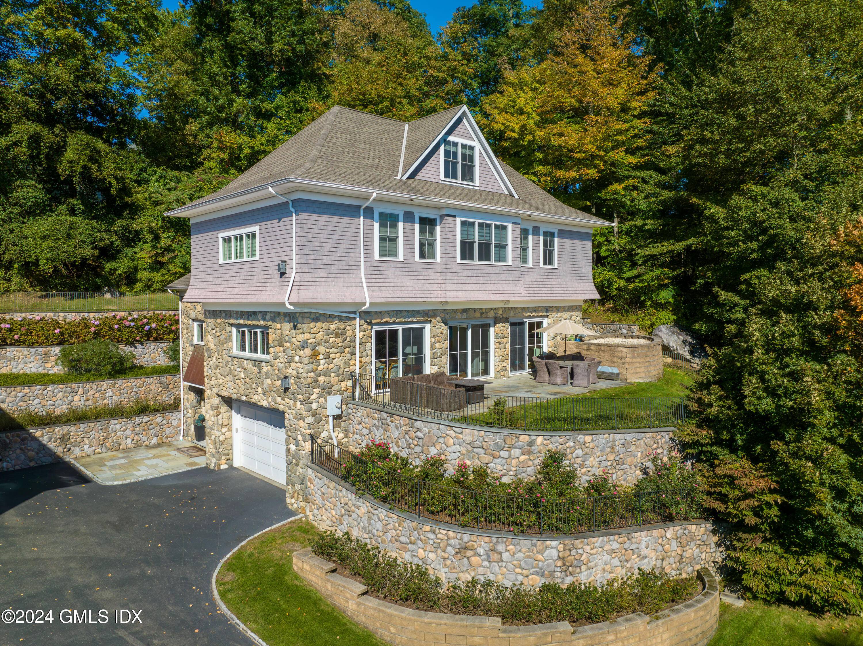 This impeccably maintained residence, crafted with stone and shingle, graces a spacious.