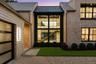 Exterior entry at dusk featuring a standing seam roof, a metal roof, and a yard
