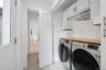 Washroom with washing machine and dryer, baseboards, light tile patterned floors, and cabinet space