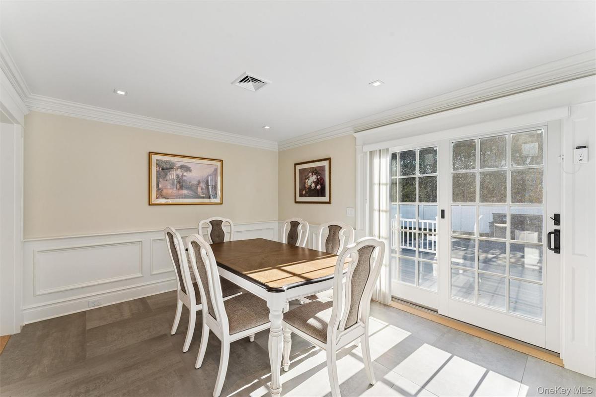 Dining space featuring wainscoted walls and crown molding.