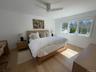 Bedroom with light wood-style flooring, baseboards, and a ceiling fan