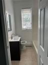 Bathroom featuring a baseboard heating unit, vanity, toilet, tile patterned flooring, and shower combination