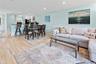 Living area with recessed lighting, a decorative wall, crown molding, and light wood-type flooring