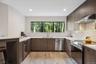 Kitchen with stainless steel appliances, a kitchen bar, a peninsula, light stone counters, and recessed lighting