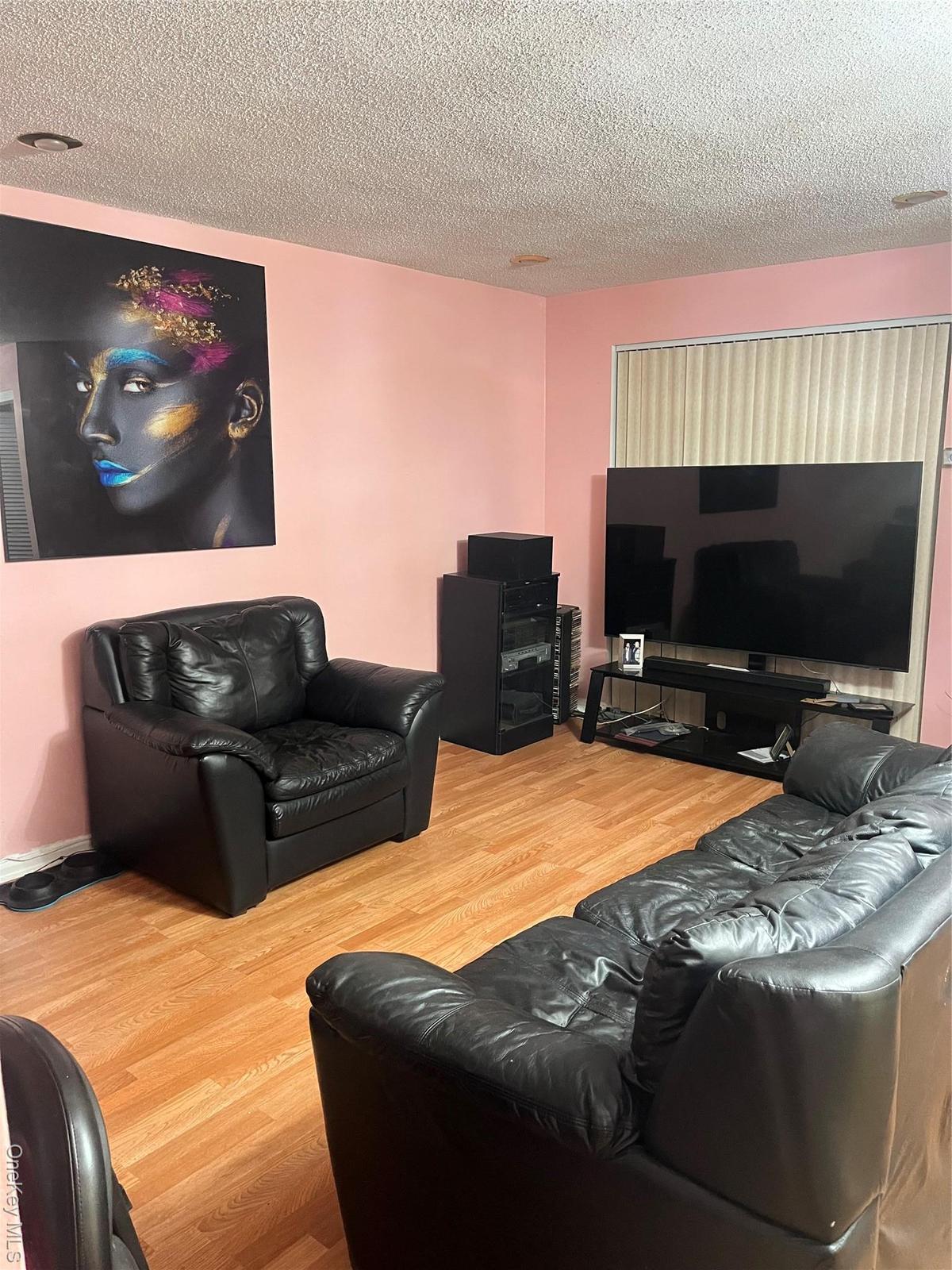 Living area with wood finished floors and a textured ceiling
