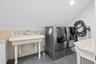Washroom with dark tile patterned flooring and washing machine and clothes dryer