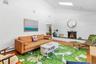 Living room with a baseboard heating unit, a skylight, a fireplace, wood-type flooring, and brick wall
