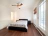 Bedroom with dark wood-style flooring, a ceiling fan, access to exterior, and baseboard heating