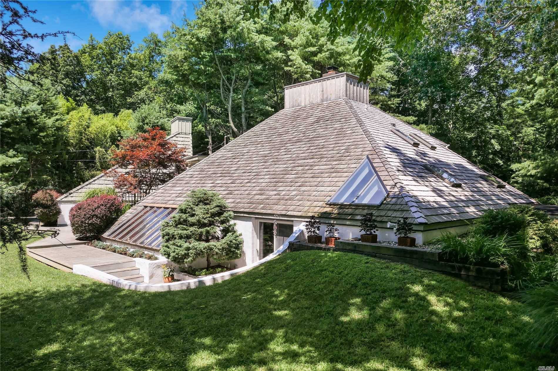 Tucked down a long driveway for ultimate privacy, this special home blends gently into its 1.