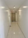 Corridor with a barn door, light tile patterned floors, and recessed lighting