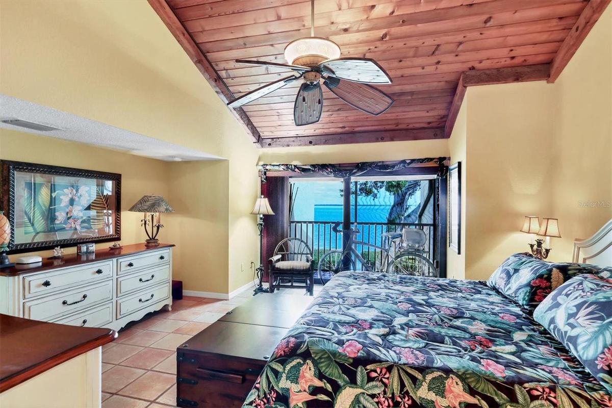 Warm & Inviting Primary Suite with Terracotta Tile, Wood Ceiling Detail, and Private Patio with Full Bay View