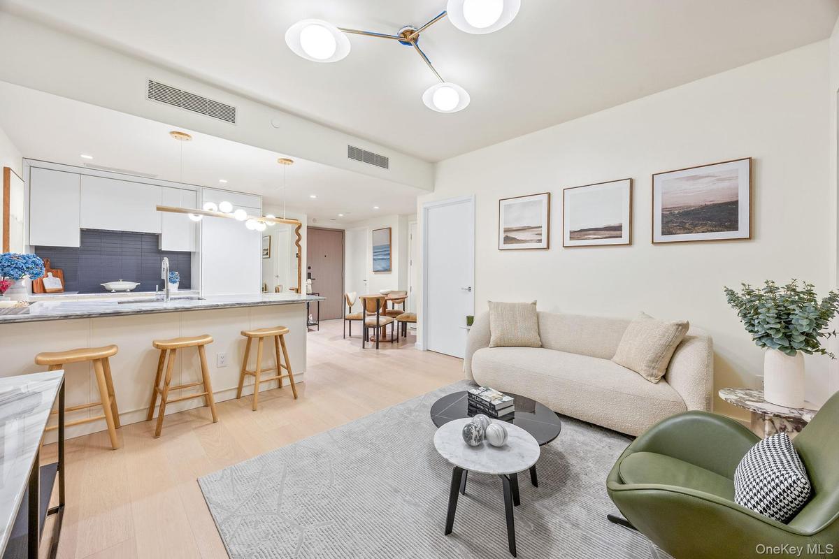 Living area with light wood-style flooring, a chandelier, and recessed lighting