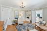 Sitting room with a baseboard radiator, light wood-style flooring, a chandelier, built in shelves, and crown molding