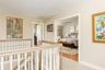 Loft on second floor with view of home office and primary bedroom