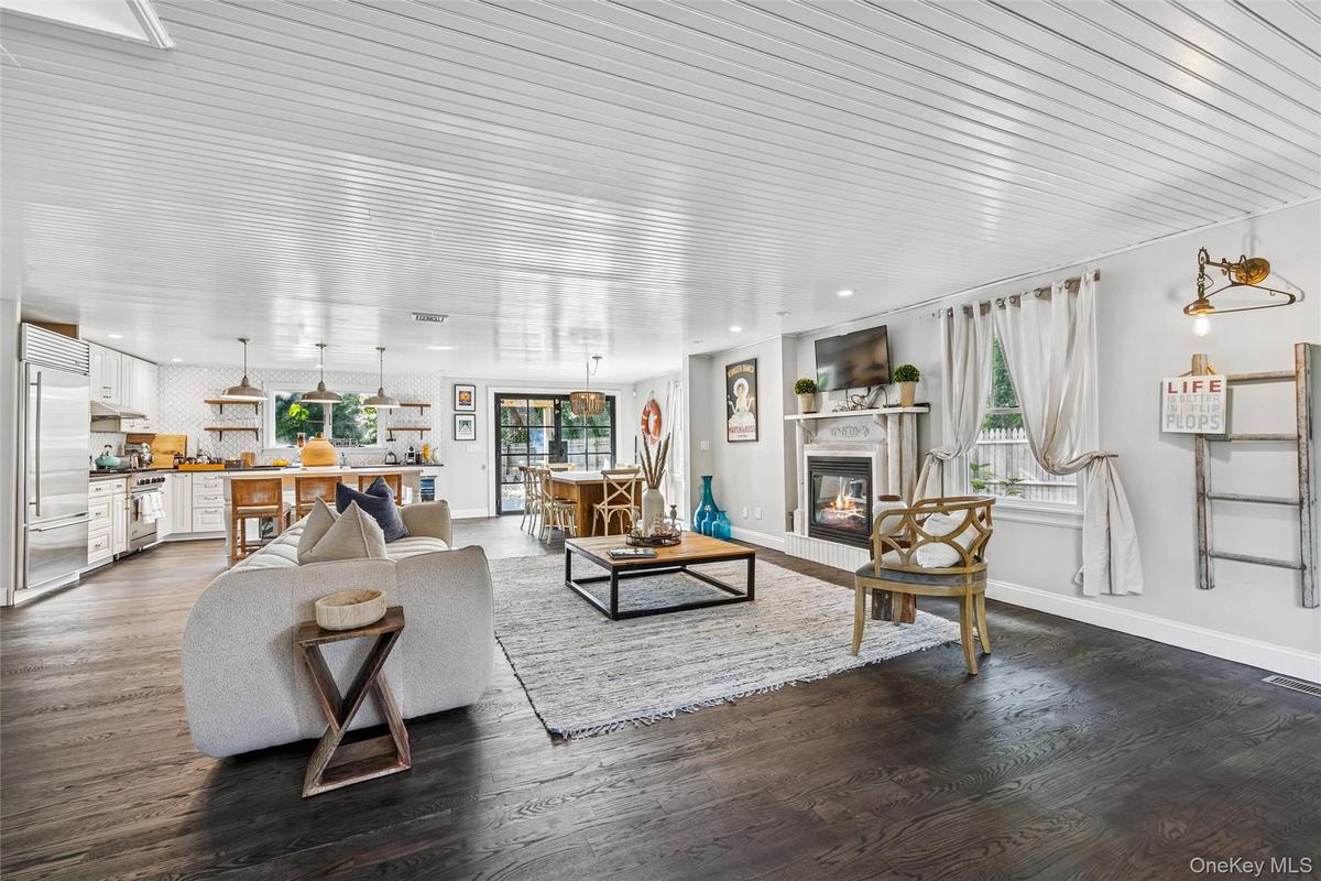 Living room with a glass covered fireplace and wood finished floors