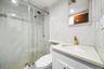 Bathroom featuring vanity and a marble finish shower