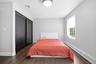 Bedroom featuring dark wood-finish flooring, light gray walls, and white trim