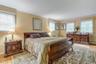 Bedroom with ornamental molding, light wood-type flooring, and baseboard heating