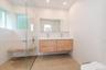 Bathroom with double vanity, walk in shower, plenty of natural light, and recessed lighting