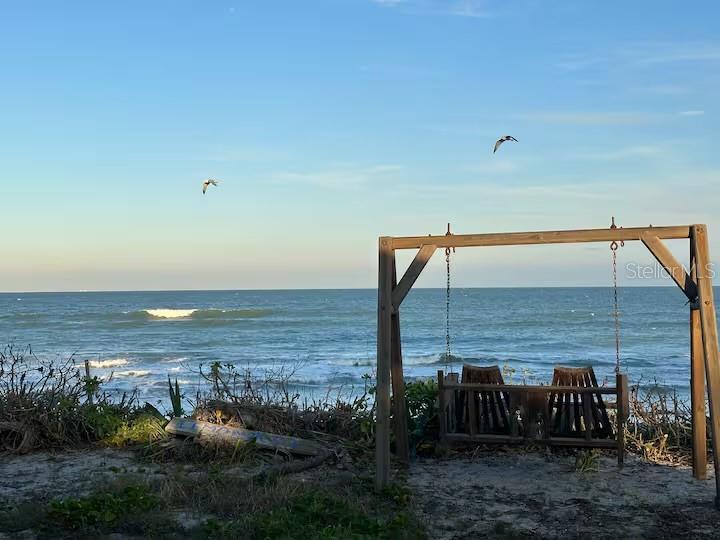A cozy oceanside swing, gently swaying with the ocean breeze.