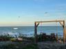 A cozy oceanside swing, gently swaying with the ocean breeze.