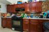 Kitchen with dark brown cabinets, backsplash, black gas stove, and under cabinet range hood