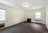 Empty room with radiator, carpet floors, and a wall mounted AC