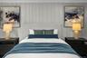 Custom wall paneling and updated lighting elevate the style and warmth of this beautifully finished bedroom.